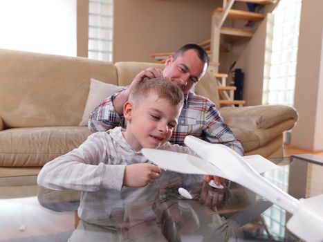 father and son assembling airplane toy at modern home living room indoor