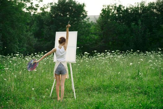 artist in nature painting a picture creative landscape back view. High quality photo