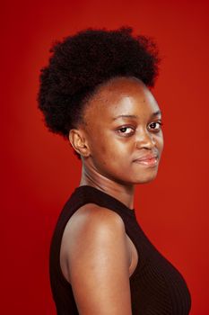 curly african woman in black t-shirt red background. High quality photo