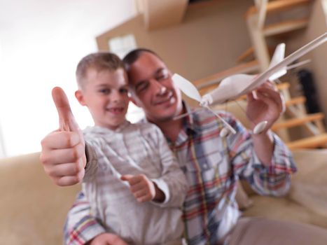 father and son assembling airplane toy at modern home living room indoor