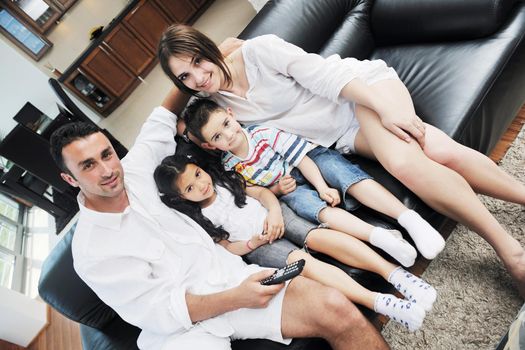 happy young family wathching flat tv at modern home indoor