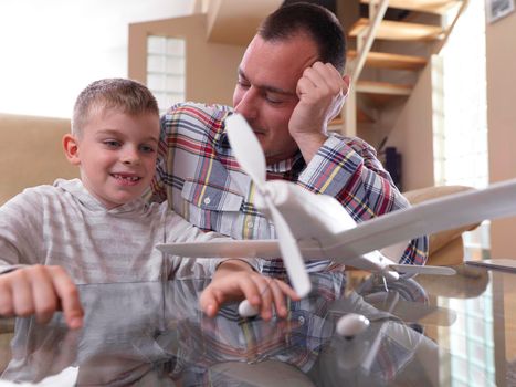 father and son assembling airplane toy at modern home living room indoor