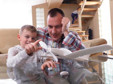 father and son assembling airplane toy at modern home living room indoor