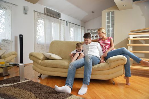 happy young family with kids in bright modern living room have fun and looking big flat lcd tv