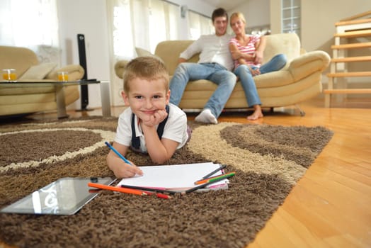 happy young family teach leassons and prepare their son for school while draw on board at home