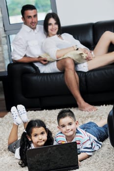 happy young family have fun and working on laptop at modern  home livingroom indoor