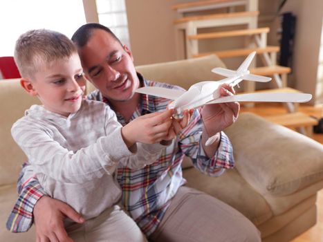 father and son assembling airplane toy at modern home living room indoor