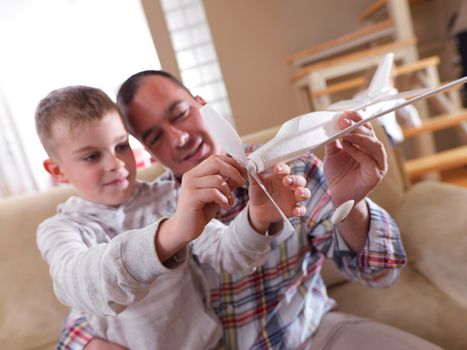 father and son assembling airplane toy at modern home living room indoor