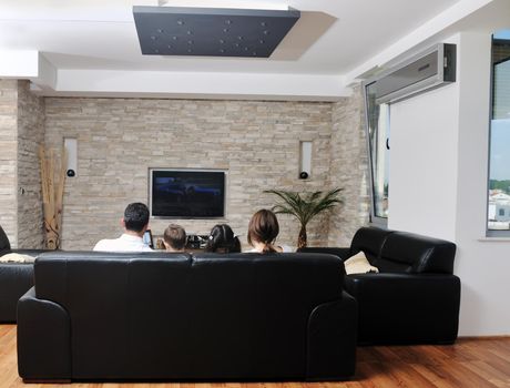 happy young family wathching flat tv at modern home indoor