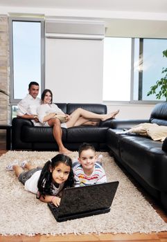 happy young family have fun and working on laptop at modern  home livingroom indoor