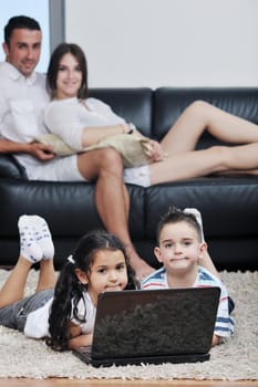 happy young family have fun and working on laptop at modern  home livingroom indoor