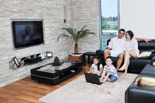 happy young family have fun and working on laptop at modern  home livingroom indoor