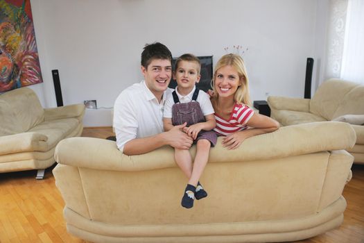 happy young family with kids in bright modern living room have fun and looking big flat lcd tv