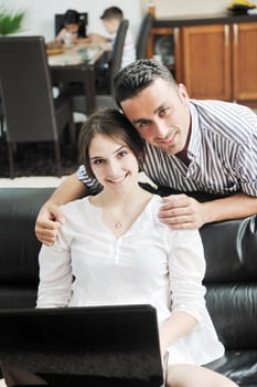 happy young family have fun and working on laptop at modern  home livingroom indoor