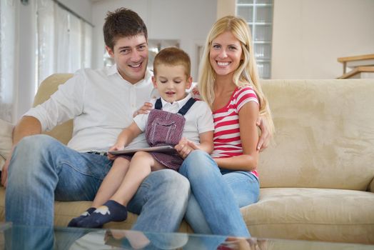 happy young family using tablet computer at modern  home for playing games and education