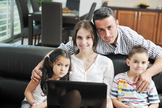 happy young family have fun and working on laptop at modern  home livingroom indoor