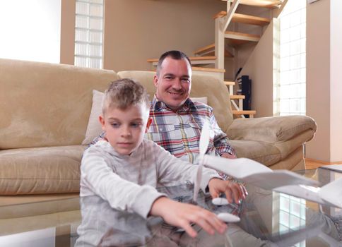 father and son assembling airplane toy at modern home living room indoor