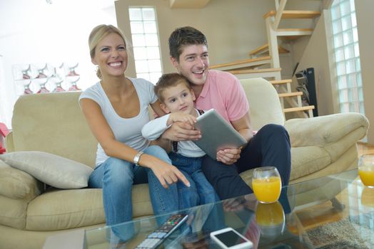 happy young family using tablet computer at modern  home for playing games and education