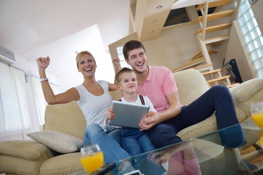 happy young family using tablet computer at modern  home for playing games and education