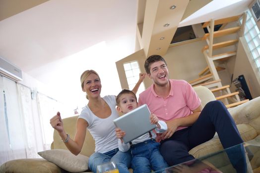 happy young family using tablet computer at modern  home for playing games and education