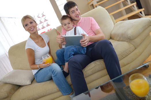 happy young family using tablet computer at modern  home for playing games and education