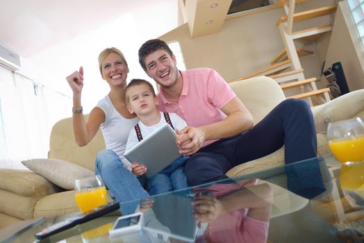 happy young family using tablet computer at modern  home for playing games and education