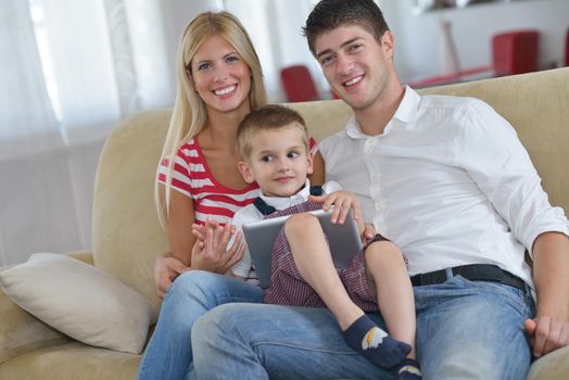 happy young family using tablet computer at modern  home for playing games and education