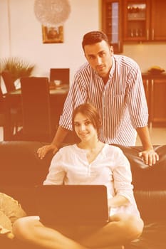 joyful couple relax and work on laptop computer at modern livingroom indoor home