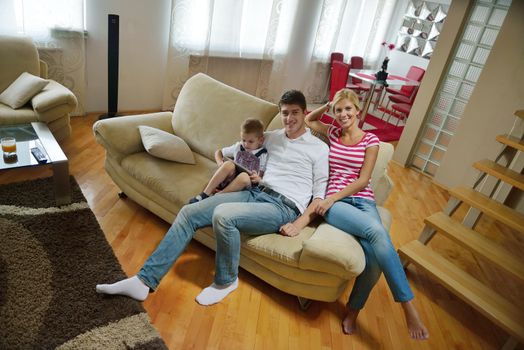 happy young family with kids in bright modern living room have fun and looking big flat lcd tv