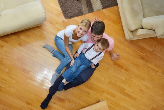 happy young family with kids in bright modern living room have fun and looking big flat lcd tv