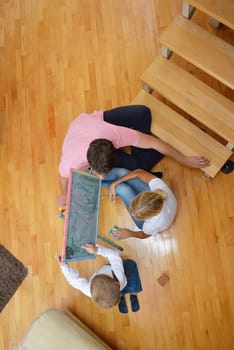 happy young family teach leassons and prepare their son for school while draw on board at home