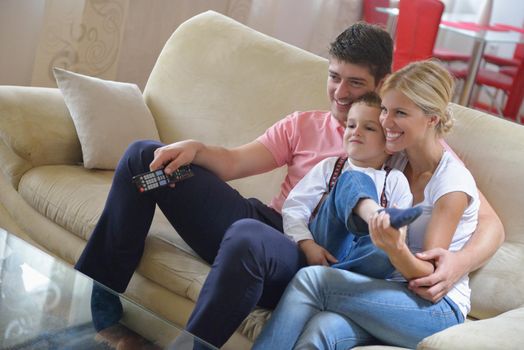 happy young family with kids in bright modern living room have fun and looking big flat lcd tv