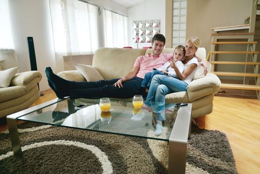 happy young family with kids in bright modern living room have fun and looking big flat lcd tv