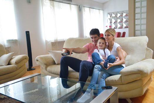 happy young family with kids in bright modern living room have fun and looking big flat lcd tv