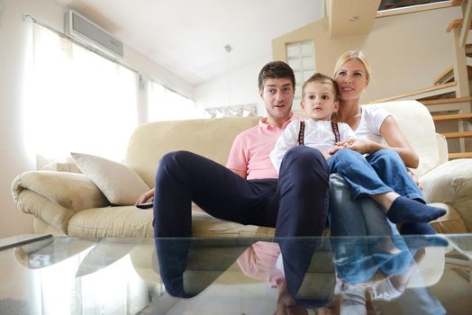 happy young family with kids in bright modern living room have fun and looking big flat lcd tv