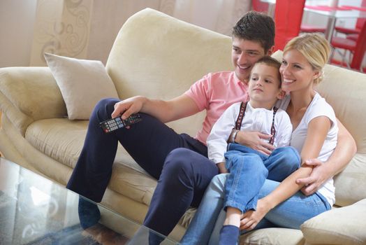 happy young family with kids in bright modern living room have fun and looking big flat lcd tv