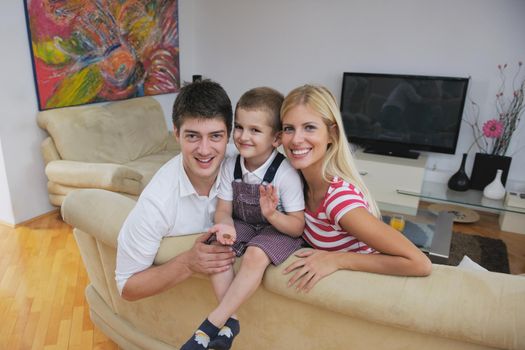 happy young family with kids in bright modern living room have fun and looking big flat lcd tv