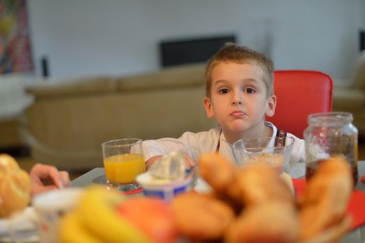 happy young family have healthy breakfast at kitchen with red details on bright morning light