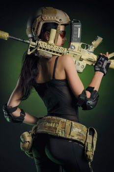 soldier girl poses with an automatic rifle