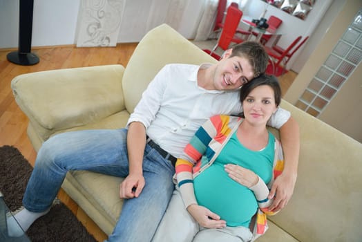 pregnant woman with her husband have fun relax and using tablet comture at modern home