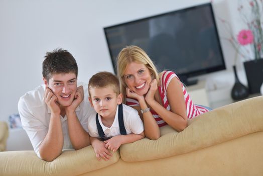 happy young family with kids in bright modern living room have fun and looking big flat lcd tv