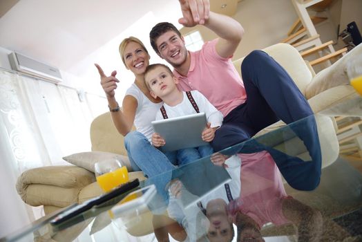 happy young family using tablet computer at modern  home for playing games and education