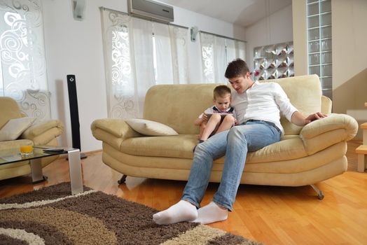 happy young family with kids in bright modern living room have fun and looking big flat lcd tv