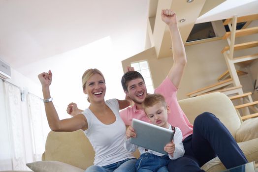 happy young family using tablet computer at modern  home for playing games and education