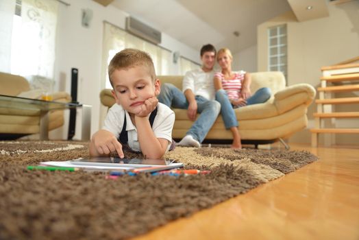 happy young family using tablet computer at modern  home for playing games and education