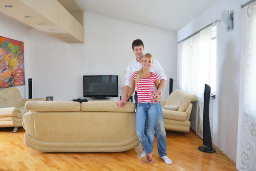 Relaxed young  couple watching tv at home in bright living room