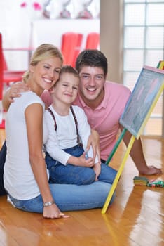 happy young family teach leassons and prepare their son for school while draw on board at home