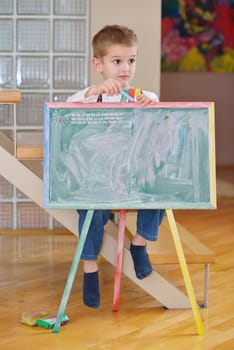 happy young family teach leassons and prepare their son for school while draw on board at home