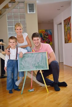 happy young family teach leassons and prepare their son for school while draw on board at home