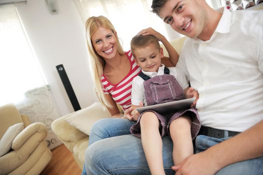 happy young family using tablet computer at modern  home for playing games and education